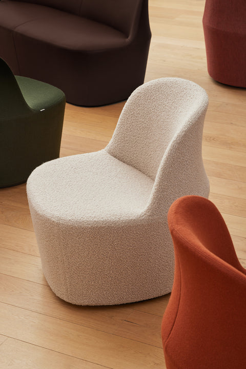 Gomo lounge seating in mixed upholsteries, cream bouclé chair with collection pieces.