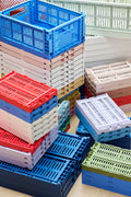 HAY Colour Crate, Medium, Red, recycled plastic storage crates, folded and stacked in blue, red, pink and cream by a window