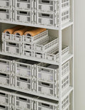 HAY Colour Crate, Small, Grey, recycled plastic storage crate, rows of grey crates filling a tall white shelving unit with paper rolls
