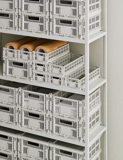 HAY Colour Crate, Small, Grey, recycled plastic storage crate, rows of grey crates filling a tall white shelving unit with paper rolls