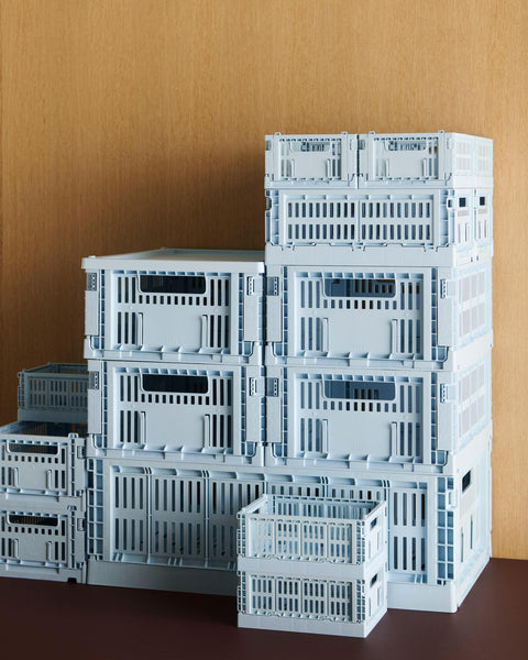 HAY Colour Crate, Mini, Soft Blue, recycled plastic storage crate, soft blue crates in several sizes stacked into a tower against a wood wall
