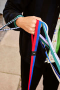 HAY Dog Leash Flat, Red and Blue, M/L, flat woven webbing dog leash, held in a hand with braided lavender and green leashes on a pavement