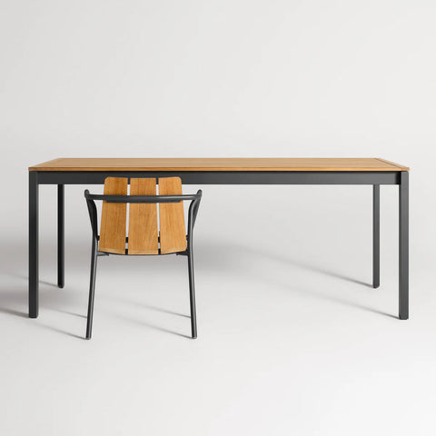 Hold Tight 76" Outdoor Dining Table by Blu Dot in Teak / Carbon, styled with Offline Outdoor Chair, front view