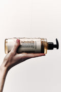 Humdakin 01 Shampoo, Chamomile & Sea Buckthorn, hair shampoo, bottle held up in a hand against a white wall