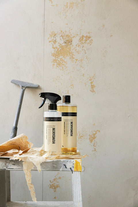 Humdakin 01 Universal Cleaner, Salvia & Sea Buckthorn, all-purpose cleaner concentrate and spray bottle on a step ladder beside a scraper and peeling paint