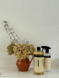 Humdakin 01 Universal Cleaner, Salvia & Sea Buckthorn, all-purpose cleaner concentrate beside a filled spray bottle and a jug of dried hydrangeas