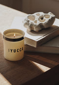Humdakin Scented Candle, Yucca, scented candle in a glass, standing on a book on a sunlit windowsill