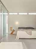 aj eklipta wall lamp in a modern bedroom designed by louis poulsen