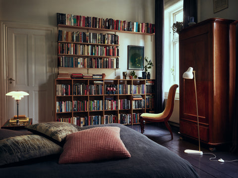 white vl38 floor lamp designed by vilhelm lauritzen in a library room for louis poulsen