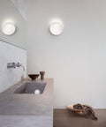 white circular scandinavian wall lamp in a bathroom 