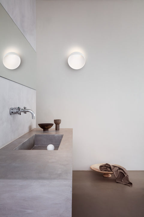 white circular scandinavian wall lamp in a bathroom 