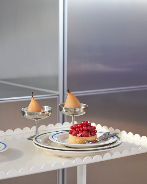 HAY Italian Ice Cup, Stainless Steel, stainless steel ice cream cup, two cups of peach dessert on a scalloped white trolley beside a berry tart