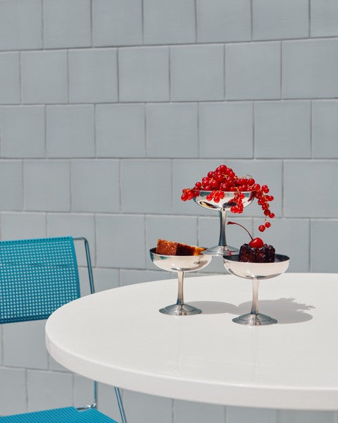 HAY Italian Ice Cup, Stainless Steel, stainless steel ice cream cup, two cups of redcurrants and cherries on a round white outdoor table