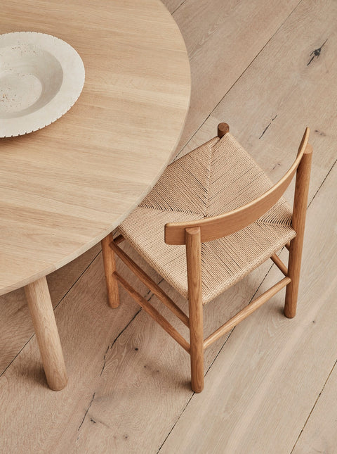 Close up of Taro round oak table and J39 paper cord chair highlighting Danish craftsmanship