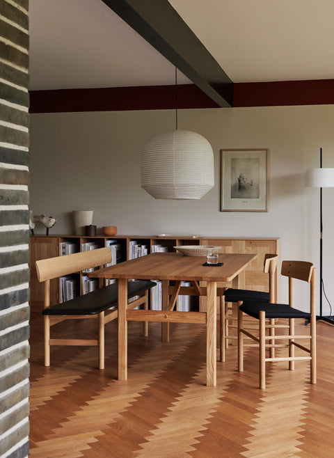 Mogensen 3171 oak bench with black leather seat shown with J39 upholstered chairs in a modern Danish dining room