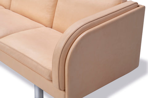 Close up of JG Sofa natural leather arm and seat with piping and brushed steel leg, premium Danish craftsmanship