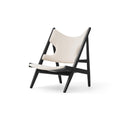 Angled view of the Knitting Lounge Chair in light upholstery and black oak frame, designed by Audo Copenhagen.