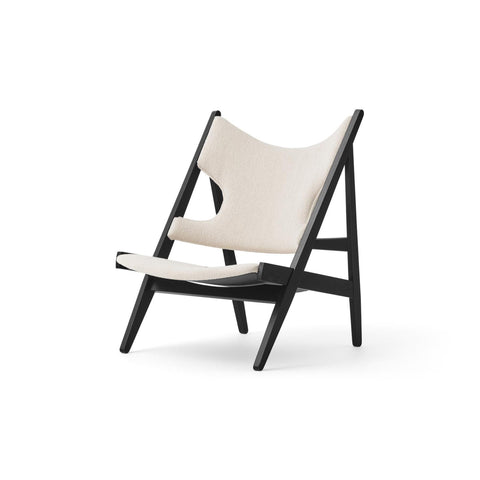 Angled view of the Knitting Lounge Chair in light upholstery and black oak frame, designed by Audo Copenhagen.