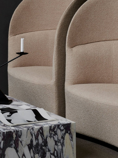 Audo Copenhagen Tearoom Lounge Chair, High Back, two textured beige Tearoom Lounge Chairs, High Back, next to a marble table with a book and candlestick