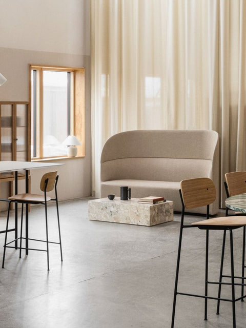 Audo Copenhagen Tearoom Sofa, High Back, beige Tearoom Sofa, High Back with US Power Outlet, in a minimalist room with a terrazzo coffee table and sheer curtains