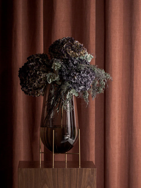 smoked glass echasse vase with brushed brass metal frame designed by theresa rand for audo copenhagen