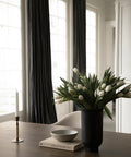 Tabletop scandinavian home decor with a black vase with flowers 