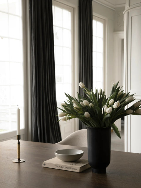 Tabletop scandinavian home decor with a black vase with flowers 