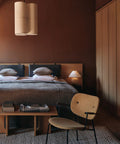 scandinavian bedroom featuring a co-lounge chair designed by norm architects and androgyne coffee table designed by Danielle Siggerud for audo copenhagen