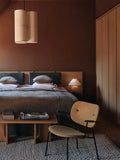 scandinavian bedroom featuring a co-lounge chair designed by norm architects and androgyne coffee table designed by Danielle Siggerud for audo copenhagen