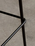 Audo Copenhagen Co Bar Chair, Non-Upholstered, close-up of the Co Bar Chair's black powder-coated steel legs, showing the joint where the footrest meets the leg