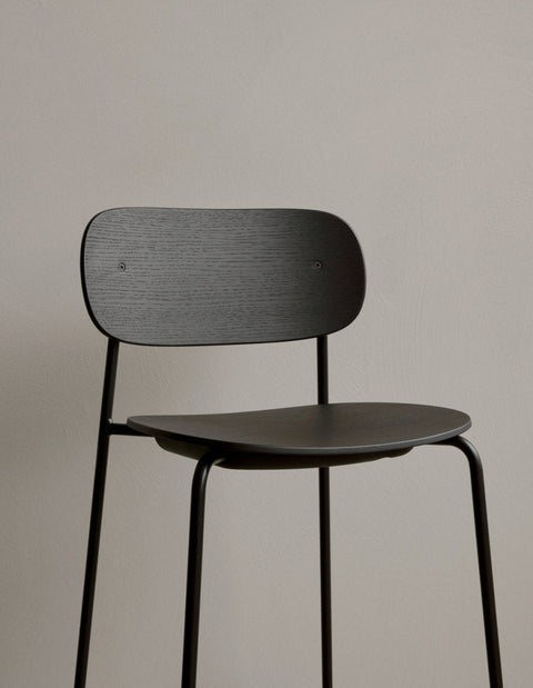 Audo Copenhagen Co Counter Chair, Non-Upholstered. A close-up of the black stained oak veneer seat and backrest on a black steel frame
