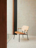 Audo Copenhagen Co Lounge Chair, Partially Upholstered, Co Lounge Chair with a natural oak back, upholstered tan leather seat, and black frame, set on a textured white rug