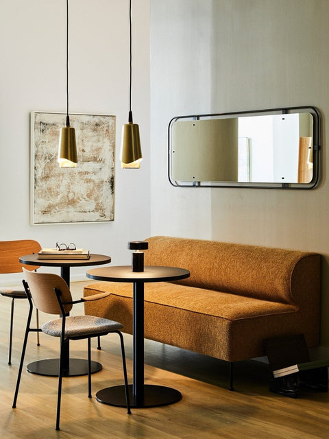 Audo Copenhagen Co Dining Chair, Non-Upholstered, dining corner with an orange Eave Dining Sofa, two Co Dining Chairs, a Column Table Lamp, and a Nimbus Mirror on the wall