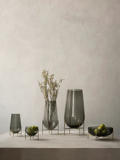 smoked glass echasse vase by theresa rand on a brushed brass metal base by audo copenhagen