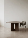 large round androgyne dining table in dark stained oak designed by Danielle Siggerud for audo copenhagen