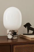 marble table lamp by audo copenhagen on walnut sideboard