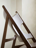 Detail view of Knitting Lounge Chair showing brown oak frame and smooth leather upholstery.