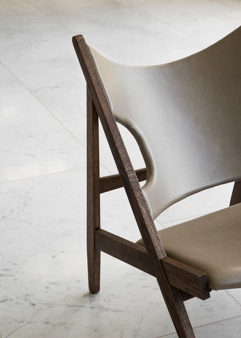 Knitting Lounge Chair in oak and leather with sculptural seat design on a marble floor.
