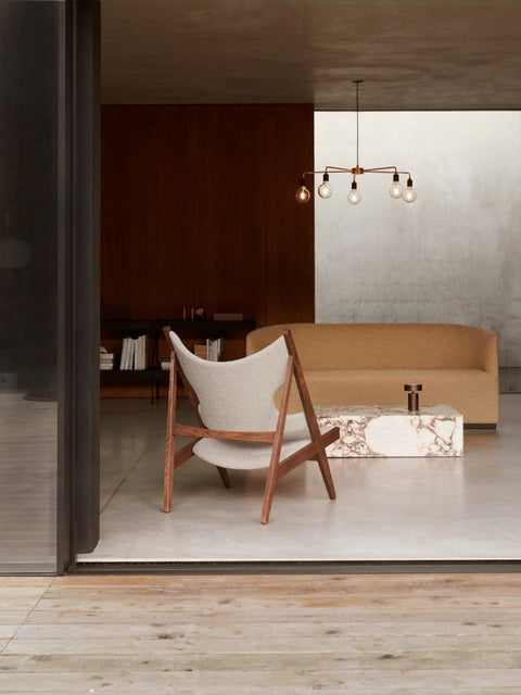 Audo Copenhagen Tearoom Swivel Chair, With Return, modern living room with a Knitting Chair, a Tearoom Sofa, and a marble Plinth coffee table under a chandelier