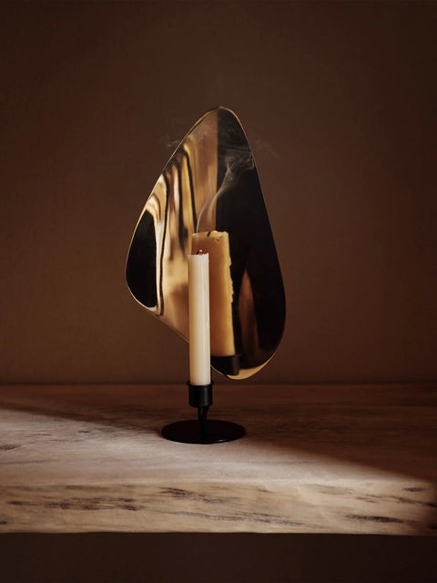 french modernish candle holder finished in brass with an organic shape by audo copenhagen