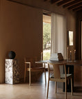 scandinavian dining room featuring a marble plinth pedestal and natural oak Merkur Dining Chair designed by Skogstad & Wærnes for audo copenhagen