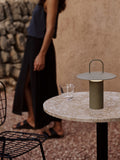 portable table lamp in dusty green by audo copenhagen