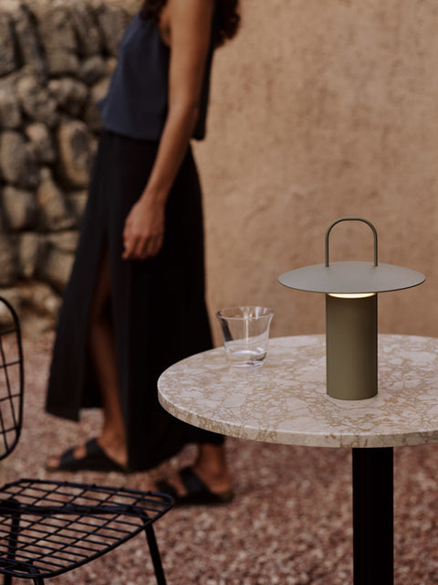 portable table lamp in dusty green by audo copenhagen