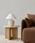 scandinavian side table with latte lamp and brown sofa