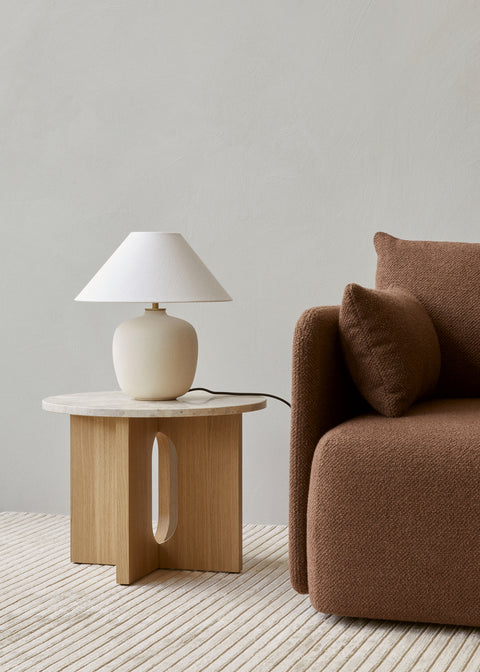 scandinavian side table with latte lamp and brown sofa