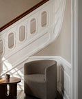 arm chair staged by a staircase in a foyer