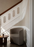 arm chair staged by a staircase in a foyer