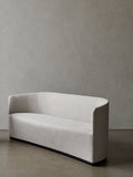 Audo Copenhagen Tearoom Swivel Chair, With Return, three-quarter view of the Tearoom Sofa in a cream fabric, featuring a sculptural curved back and a recessed black base