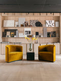 Audo Copenhagen Tearoom Chairs and Sofas, yellow velvet Tearoom Chairs face each other in front of a wooden shelving unit filled with material and art samples