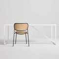 Made You Look Outdoor Chair by Blu Dot in Oblivion with plastic rattan seat and back, rear view with dining table